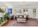 Cozy living room boasting a decorative fireplace, a large window, and hardwood floors at 1454 Utica St, Denver, CO 80204