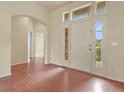 Bright and airy foyer with hardwood floors, arched doorway, and transom windows above the entrance at 297 N Coolidge Way, Aurora, CO 80018