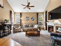 Inviting living room featuring a vaulted ceiling, fireplace, neutral carpet, and large windows at 5261 S Malta Way, Centennial, CO 80015