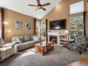 Cozy living room with a fireplace, comfortable seating, a large TV, and natural light at 5261 S Malta Way, Centennial, CO 80015