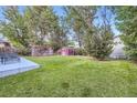 Lush backyard with a red shed, chicken coop, and mature trees at 2982 S Vrain St, Denver, CO 80236