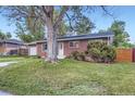 Single-story brick home with a large tree in the front yard and a grassy lawn at 2982 S Vrain St, Denver, CO 80236