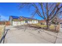 Inviting home featuring solar panels, a spacious driveway, and a well-kept yard under a blue sky at 1205 S Argonne Cir, Aurora, CO 80017