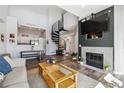 Stylish living room featuring a fireplace, dark wood accent wall, spiral staircase, and open flow to the kitchen at 8707 E Florida Ave # 814, Denver, CO 80247
