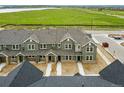 Aerial view of townhomes showcasing green exteriors, open fields, and a scenic view at 17115 W 91St Ln, Arvada, CO 80007