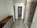 Modern bathroom with gray-tiled shower and unfinished vanity at 17115 W 91St Ln, Arvada, CO 80007