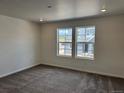 Cozy bedroom featuring plush carpeting and two bright windows overlooking the community at 17115 W 91St Ln, Arvada, CO 80007