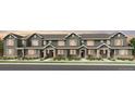 Charming townhome exterior with gray siding, stone accents, and well-maintained landscaping at 17115 W 91St Ln, Arvada, CO 80007