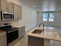 Well-lit kitchen featuring stainless steel appliances, light wood floors and gray cabinets at 17115 W 91St Ln, Arvada, CO 80007