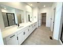 Spacious bathroom featuring dual sinks, white cabinetry, and a walk-in shower at 3443 N Denali St, Aurora, CO 80019