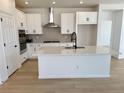 Modern kitchen with white cabinets, stainless steel appliances, and a large center island at 3443 N Denali St, Aurora, CO 80019
