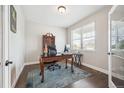 Well-lit home office with dark wood floors, ornate desk, and large window with natural light at 17409 Springfield Dr, Parker, CO 80134