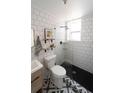 Bathroom featuring black fixtures, a patterned tile floor, subway tile, and glass enclosed shower at 215 E 11Th Ave # A5, Denver, CO 80203