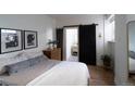 Cozy bedroom showcasing a sliding barn door leading to the bathroom with a patterned tile floor at 215 E 11Th Ave # A5, Denver, CO 80203