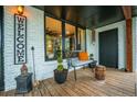 Cozy front porch featuring wood flooring, charming decor, a black door, and white painted brick at 3125 Xenon St, Wheat Ridge, CO 80215