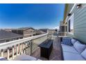 Relaxing deck area with outdoor furniture, fire table, and neighborhood views at 2153 Abigail Ln, Castle Rock, CO 80104