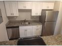 Modern kitchen with granite counters, stainless steel appliances, and white cabinets at 12148 Melody Dr # 108, Denver, CO 80234