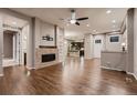 Open-concept living room featuring hardwood floors and a brick fireplace, transitioning into the adjacent kitchen at 3703 New Haven Cir, Castle Rock, CO 80109