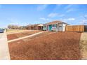 Single-story home with a bright blue door, complemented by a well-maintained lawn and wood-chip landscaping at 3630 Magnolia St, Denver, CO 80207