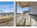 Covered front porch with white columns and railing, stone accents and professional landscaping at 24709 E 39Th Ave, Aurora, CO 80019