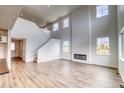 Spacious living room featuring tall ceilings, a modern fireplace, hardwood floors, and a staircase at 2197 S Jackson Gap St, Aurora, CO 80018