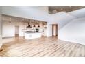 Open-concept layout with views of kitchen, tall ceilings, hardwood floors, and staircase at 2197 S Jackson Gap St, Aurora, CO 80018