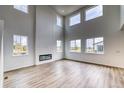 Bright living room with high ceilings, a modern fireplace, and large windows offering ample natural light at 2197 S Jackson Gap St, Aurora, CO 80018