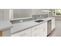 Beautiful kitchen featuring white cabinets, stainless steel appliances and grey quartz countertops at 2046 S Quitman St, Denver, CO 80219