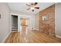 Bright living room with hardwood floors, exposed brick, and staircase access at 709 27Th St, Denver, CO 80205