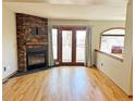 Inviting living room has hardwood floors, stone fireplace, french doors, and bright windows at 611 E 7Th Ave, Denver, CO 80203