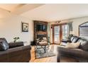 Cozy living room featuring a fireplace and access to a deck at 611 E 7Th Ave, Denver, CO 80203