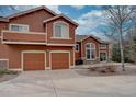 Exterior view of a home featuring a two-car garage, a balcony, and a patio at 19414 E Mann Creek Dr # C, Parker, CO 80134
