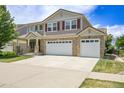Charming two-story home featuring a three car garage, landscaped lawn, and brick accents, with great curb appeal at 5131 Netherland St, Denver, CO 80249