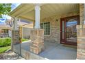 Inviting front porch with brick pillars and a glass-paneled door, creating a warm welcome to the home at 5131 Netherland St, Denver, CO 80249