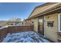 Front entrance with wooden deck and snow on the ground at 68 W 81St Pl, Denver, CO 80221