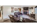 Living room with fireplace and brown leather furniture at 68 W 81St Pl, Denver, CO 80221