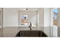 Open concept kitchen with stainless steel faucet and granite countertops at 5913 Sawdust Dr, Brighton, CO 80601