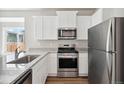 Modern kitchen featuring stainless steel appliances, granite countertops and white cabinets at 5913 Sawdust Dr, Brighton, CO 80601