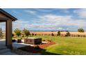 Secluded backyard featuring a hot tub and expansive grassy area with views of the surrounding landscape at 953 Compass Dr, Erie, CO 80516