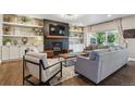 Stylish living room with a fireplace, built-in shelving, hardwood floors and comfortable seating at 1300 W 13Th Ave, Broomfield, CO 80020