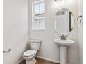 Clean powder room with pedestal sink and oval mirror at 674 Penn Rd, Elizabeth, CO 80107