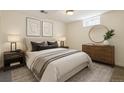 Cozy bedroom with neutral decor, comfortable bedding, modern artwork, and a round mirror above the dresser at 7065 Ingalls Ct, Arvada, CO 80003
