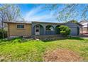 Charming single-story home featuring a blue exterior, arched doorway, and a well-maintained front yard at 7065 Ingalls Ct, Arvada, CO 80003