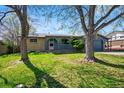 Charming single-story home featuring a blue exterior, arched doorway, and a well-maintained front yard at 7065 Ingalls Ct, Arvada, CO 80003