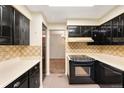 A galley kitchen featuring black cabinets with matching appliances at 9043 W Warren Dr, Lakewood, CO 80227
