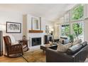 Bright living room features a brick fireplace, vaulted ceilings, and large windows with shutters at 7264 Wembley Pl, Castle Pines, CO 80108