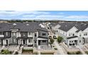 Aerial view of a neighborhood showcasing modern homes, well-manicured lawns, and mountain views in the distance at 2054 S Upham Way, Denver, CO 80227