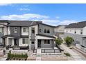 Modern two-story home showcasing gray siding, stone accents, and a cozy front porch in a residential area at 2054 S Upham Way, Denver, CO 80227