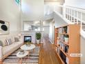 Bright living room with a fireplace, hardwood floors, and staircase to the second floor at 441 Grey Swallow St, Brighton, CO 80601