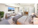 Bright main bedroom featuring a large window, ensuite bathroom, and neutral decor at 441 Grey Swallow St, Brighton, CO 80601